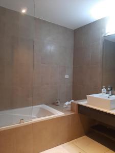 a bathroom with a bath tub and a sink at Relajate en un hermoso apartamento Duplex cerca de la playa y piscina en Playa Blanca, Farallon in Río Hato