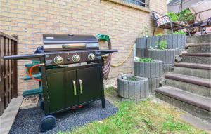 a grill in a yard next to a brick building at Amazing Apartment In Berlin-bohnsdorf With 1 Bedrooms And Wifi in Berlin