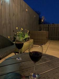 two glasses of red wine sitting on a wooden table at Brada View Bamburgh in Bamburgh