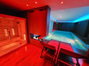 a swimming pool with a table and chairs in a room at Alysa - Suite Wellness & Spa in Giarre