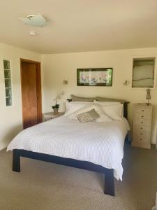 a bedroom with a large bed with white sheets at Otago Peninsula Paradise in Dunedin