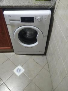 a washing machine in a corner of a room at Bed Space in Dubai