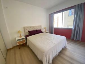 ein Schlafzimmer mit einem weißen Bett und einem großen Fenster in der Unterkunft Departamento en Caballito in Buenos Aires + 8 Fotos