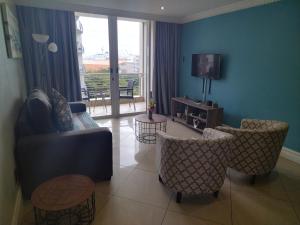 ダーバンにあるSails Luxury 1 Bedroom Apartmentのソファと椅子とテレビのあるリビングルーム