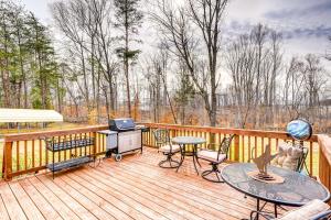 a deck with a table and chairs and a tv at Browns Summit Vacation Rental with Fire Pit! in Monticello