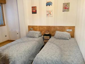 two beds sitting next to each other in a bedroom at Costa da morte in Malpica