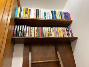 ein Bücherregal voller Bücher an einer Wand in der Unterkunft Larocca Tourist Home 1 in Bassano del Grappa