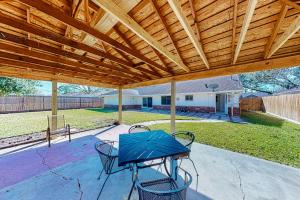 un patio con mesa y sillas bajo un techo de madera en Briarbend Beauty, en Houston