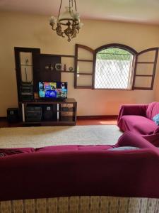 a living room with a couch and a mirror at Casa Aconchegante - Circuito Teresópolis Friburgo in Teresópolis