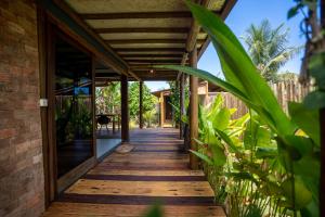 a wooden walkway leading to a house with plants at Taipu Loft - Península de Maraú in Marau