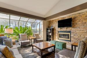 a living room with a fireplace and a stone wall at Best Western Plus Forest Park Inn in Gilroy