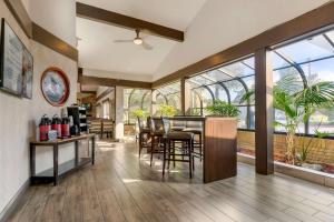 a dining room with a table and chairs and windows at Best Western Plus Forest Park Inn in Gilroy