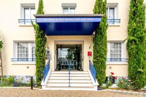 un bâtiment avec une porte bleue et du lierre dans l'établissement Best Western Le Vinci Loire Valley, à Amboise