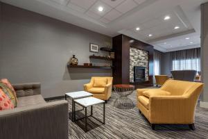 a lobby with two chairs and a couch and a fireplace at Best Western Plus The Hammondsport Hotel in Hammondsport