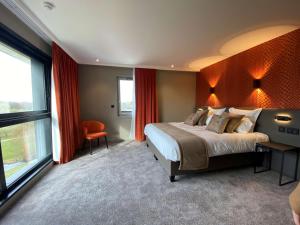 a bedroom with a large bed and a large window at Best Western Plus Le Fairway Hotel & Spa Golf d'Arras in Anzin-Saint-Aubin