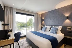アンザン・サン・トーバンにあるBest Western Plus Le Fairway Hotel & Spa Golf d'Arrasのベッドと大きな窓が備わるホテルルームです。