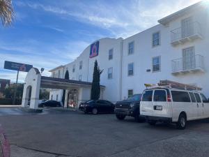 Motel 6 Dallas TX Downtown في دالاس: سيارة فان بيضاء متوقفة أمام مبنى