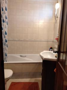 y baño con bañera, aseo y lavamanos. en Casa Vista, en Alcalá de los Gazules