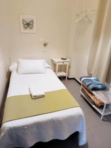 ein Schlafzimmer mit einem Bett, einem Tisch und einem Stuhl in der Unterkunft Pension Perez Montilla in Sevilla
