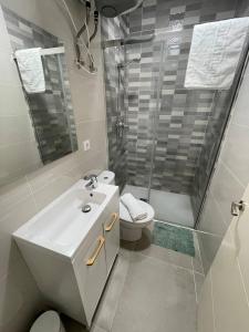 y baño con lavabo, ducha y aseo. en Encantador Apartamento en Lebrija, en Lebrija