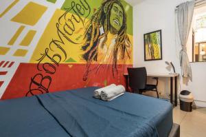 a bedroom with a bed with a painting on the wall at Casa Clandestina in Medellín