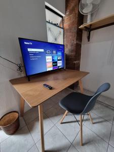 a computer monitor on a wooden desk with a chair at Casa Hostal La Esperanza de Don Alfonso in León