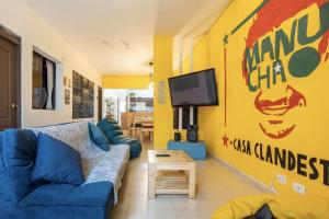 ein Wohnzimmer mit einem blauen Sofa und einem TV in der Unterkunft Casa Clandestina Guest House in Medellín