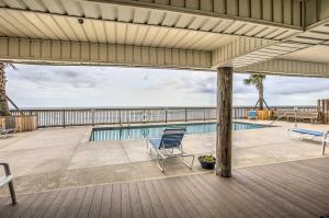 a patio with a chair and a swimming pool at Murrells Inlet Condo on Garden City Beach! in Myrtle Beach