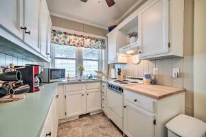 a white kitchen with white cabinets and a window at Quaint Home with Porch in Downtown Waynesville! in Waynesville