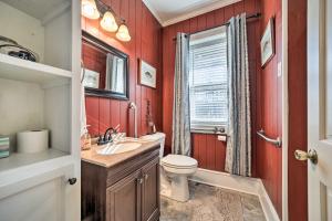 a bathroom with red walls and a toilet and a sink at Quaint Home with Porch in Downtown Waynesville! in Waynesville +19 photos
