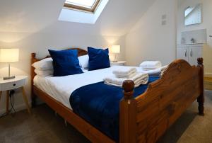 a bedroom with a large wooden bed with blue pillows at Achintee Cottages No 2 in Fort William