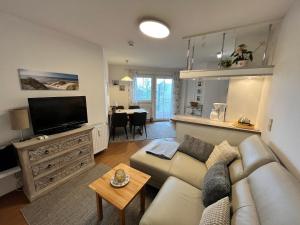 a living room with a couch and a flat screen tv at Residenz am Yachthafen, Whg 12 in Grömitz