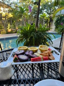 a tray of fruit on a table next to a pool at Orchid Cottage in Kingston