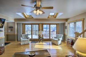 a living room with a ceiling fan and a couch and chairs at Charming Lake Ripley Cottage with Water View! in Cambridge