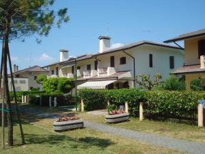 Une rangée de maisons fleuries dans une cour dans l'établissement Holiday Homes in Porto Santa Margherita 43919, à Porto Santa Margherita