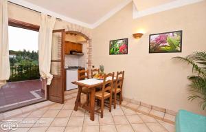 a kitchen and dining room with a table and chairs at Apartments in Pula Sardinien Cagliari Provinz 43440 in Foxiʼe Sali +14 photos
