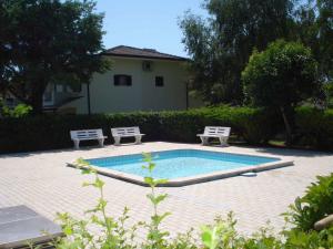 - une piscine avec 2 chaises et une table dans l'établissement Holiday Homes in Porto Santa Margherita 43919, à Porto Santa Margherita