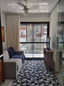 uma sala de estar com um sofá, uma mesa e uma janela em Apartamento próximo ao Farol da Barra em Salvador