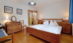 Schlafzimmer mit einem Bett, einer Kommode und einem Spiegel in der Unterkunft Ferienwohnung Schmiedhofer in Ellmau