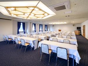 宮崎市にあるエアラインホテルのテーブルと椅子が並ぶ部屋