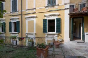 una casa con persiane verdi e piante in vaso di fronte ad essa di Holiday home in Florenz - Toskana 43634 a Firenze