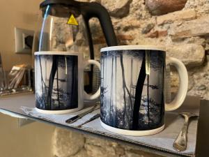 two blue and white coffee cups sitting on a shelf at DeLax B&B - adults only in Solferino