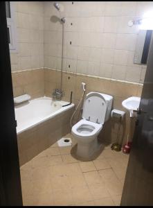 ein Badezimmer mit einer Badewanne, einem WC und einem Waschbecken in der Unterkunft Bed Space in Dubai