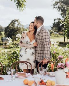 Una novia y un novio parados frente a una mesa en Villa Provence en Pokolbin