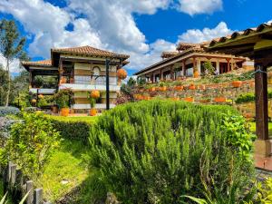 a house with a garden in front of it at Posada María del Carmen in Ráquira