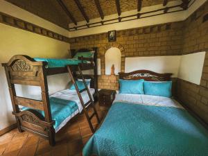 a bedroom with two bunk beds and a bed at Posada María del Carmen in Ráquira