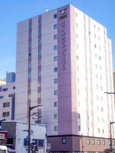 a large building with a sign on the side of it at Smile Hotel Premium Sapporo Susukino in Sapporo
