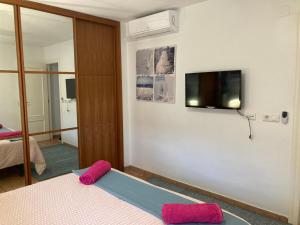 ビナロスにあるDuplex Beach Side Modern Apartment with Terraceの壁にテレビとベッドが備わる客室です。
