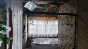 a bathroom with a bath tub and a window at Pousada Grom's Village in Campos do Jordão