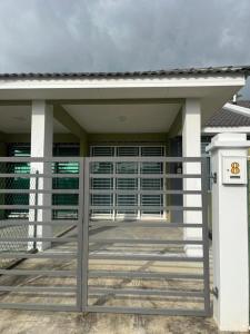 a front door of a house with a gate at Homestay Bonda in Kampong Masjid Tanah